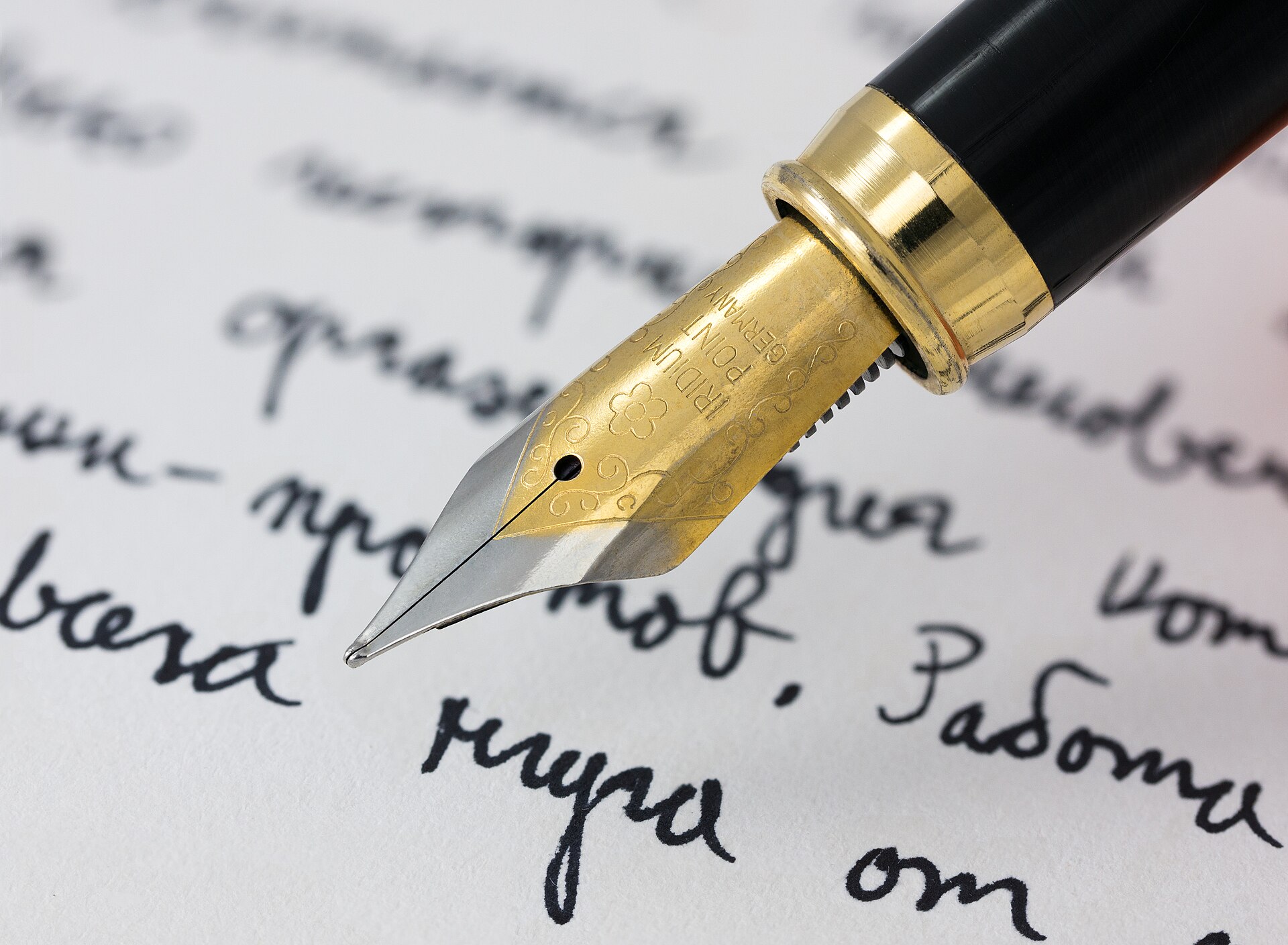 Cyrillic Handwriting | Movies Fan Club A gold fountain pen writes Cyrillic script on paper, evoking the atmosphere of classic cinema.